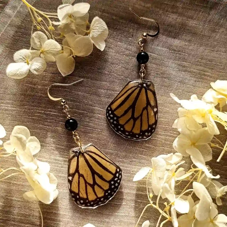 Boucles d'oreilles pendantes avec ailes de papillon Danaus plexippus dans résine et pierre d'onyx.