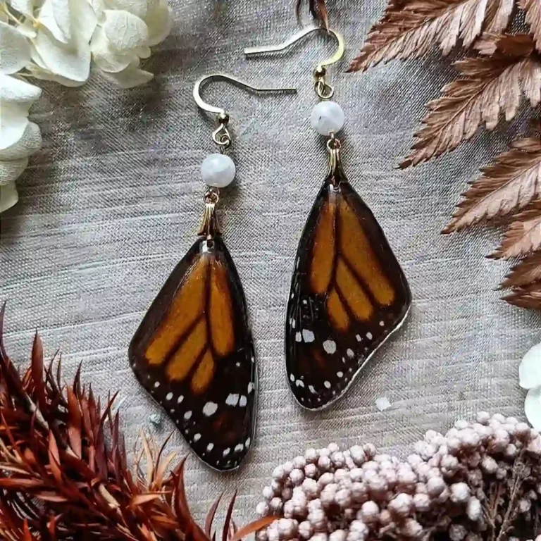 Boucles d'oreilles pendantes avec ailes de papillon Danaus plexippus dans résine et pierre de lune.