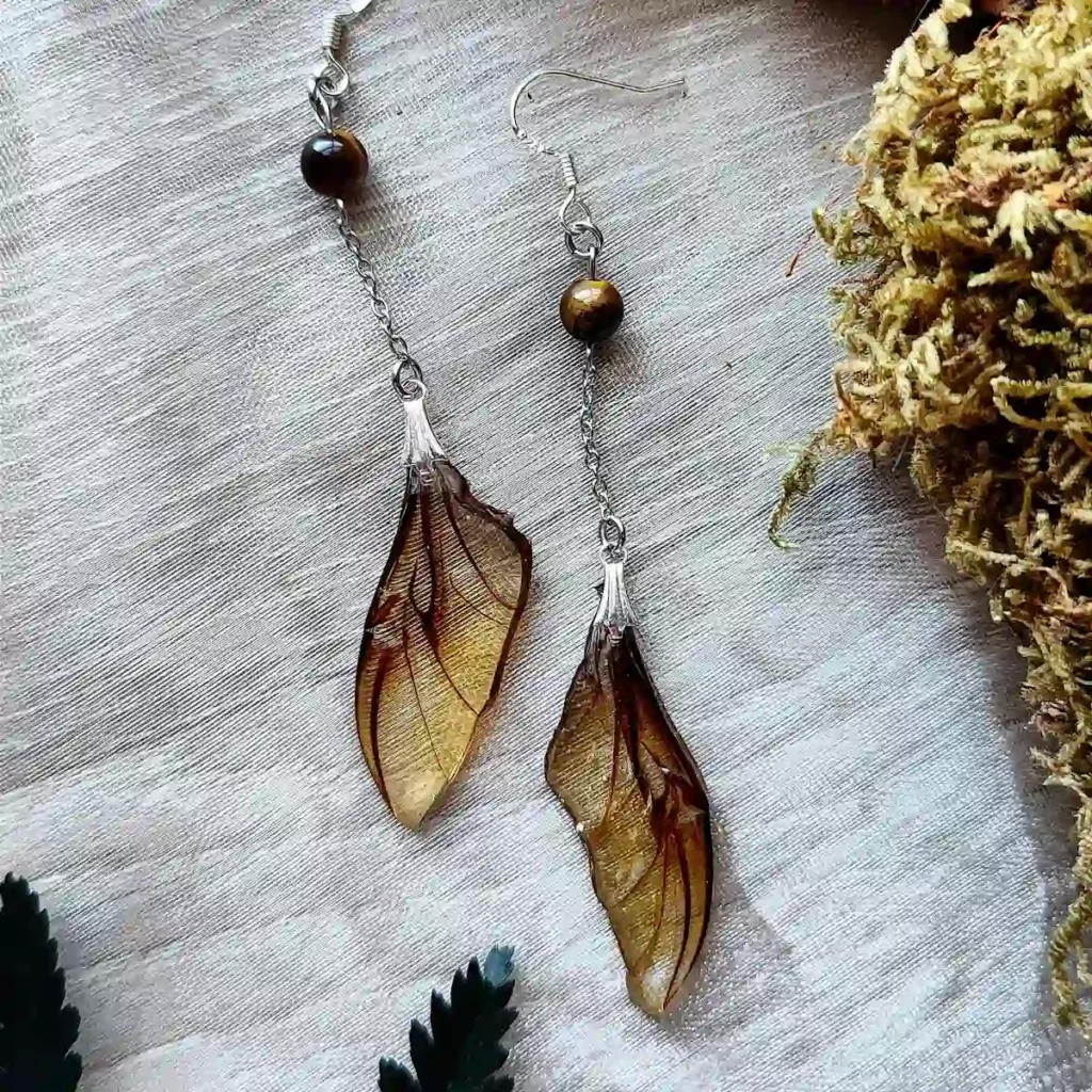 Boucles d'oreilles pendantes avec ailes de scarabée dans résine et pierre œil de tigre.