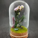 Cloche entomologique avec diorama montrant une gyne de fourmis Messor barbarus et des abeilles Apis mellifera, décoré de fleurs, de végétaux et de pierres d'agate indienne.