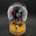 Cloche entomologique avec diorama montrant un papillon Milionia fulgida, décoré de pierre d'obsidienne.