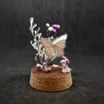 Cloche entomologique avec un papillon Sevenia pechueli, décoré de quartz rose.