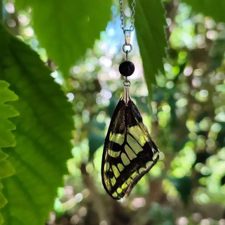 Collier avec pendentif en résine contenant une aile de papillon Papilio machaon, décoré de pierre d'obsidienne.